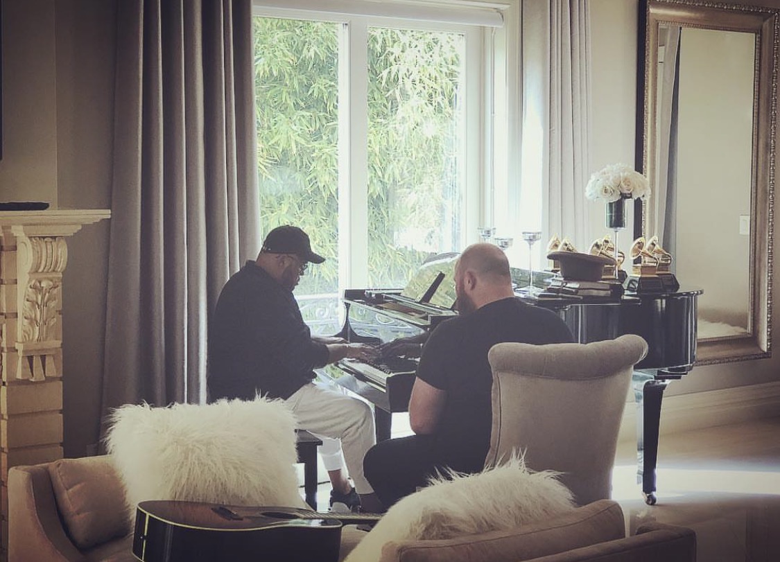 Justin writing with Israel Houghton at a piano