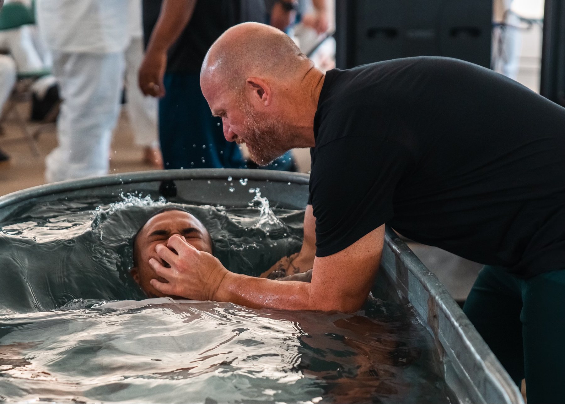 Justin assisting with a baptism during a ministry gathering