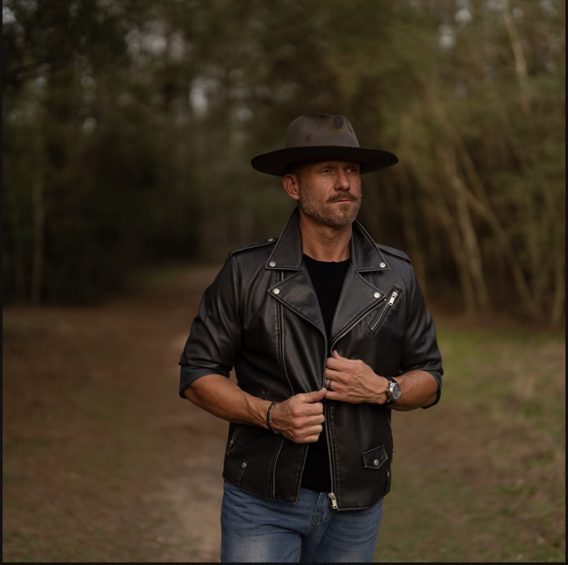 A recent portrait of Justin in a leather jacket and hat