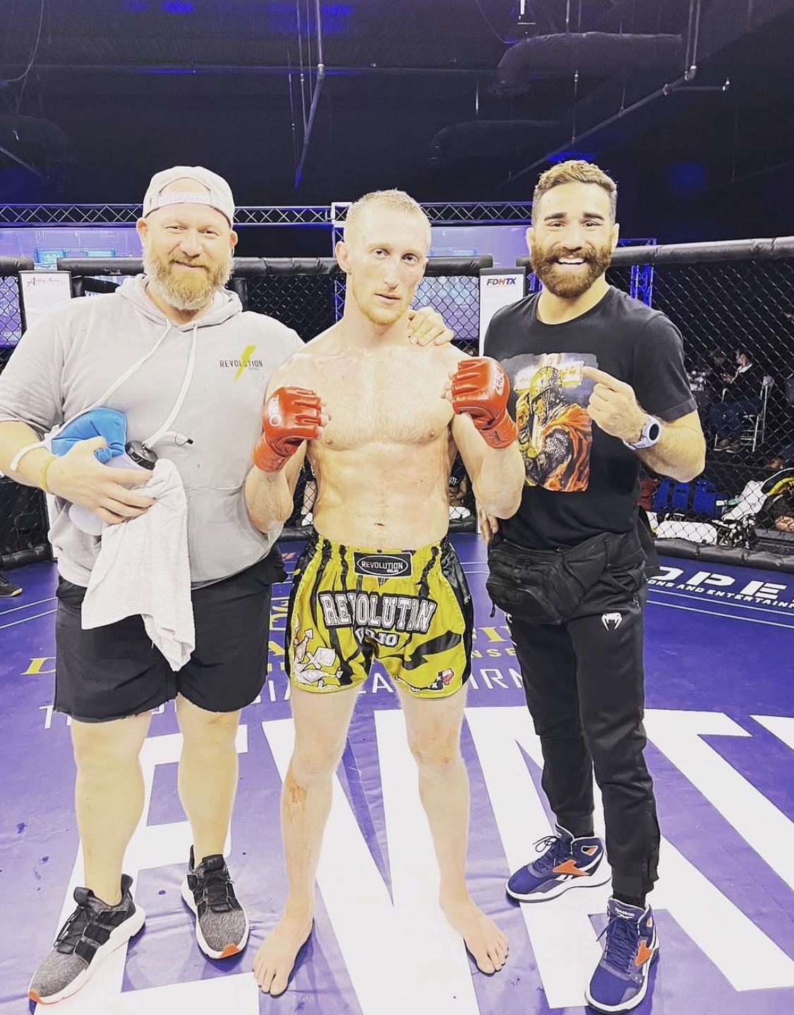 Justin coaching a fighter inside the MMA cage after a bout